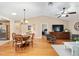 Inviting living space with dining table, television, wood floors, and seamless flow to the kitchen at 1502 Blueberry Way, The Villages, FL 32162
