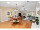 Open-concept living area with hardwood floors, dining set, comfortable seating, and natural light at 1502 Blueberry Way, The Villages, FL 32162