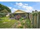 Backyard features a screened patio, lush landscaping, and a verdant, well-maintained lawn at 1512 S Pointe Dr, Leesburg, FL 34748