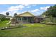Backyard with lush lawn, garden, and screened lanai, perfect for outdoor living at 1512 S Pointe Dr, Leesburg, FL 34748