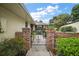 Inviting walkway with brick columns and wrought iron gate, enhanced by lush landscaping at 1512 S Pointe Dr, Leesburg, FL 34748