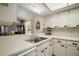Bright kitchen with a double sink, white cabinets, and a pass-through to the living area at 1512 S Pointe Dr, Leesburg, FL 34748