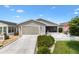 Charming single-story home with gray siding, a well-maintained lawn, a white picket fence, and a convenient attached garage at 1513 Lozano Ave, The Villages, FL 32159
