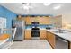 Updated kitchen featuring stainless steel appliances and light wood cabinets at 1513 Lozano Ave, The Villages, FL 32159