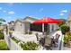 Enjoy outdoor living with a spacious patio including a dining set and an umbrella near the house and a pretty fountain at 1513 Lozano Ave, The Villages, FL 32159