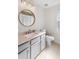 Clean bathroom with marble countertop, round mirror and plenty of sunlight at 15501 Markham Dr, Clermont, FL 34714