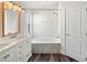 Bright bathroom with double vanity, tiled floors, shower, and a soaking tub with mosaic tile at 15501 Markham Dr, Clermont, FL 34714