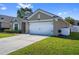 Charming single-story home featuring a well-manicured lawn and an attached two-car garage at 15501 Markham Dr, Clermont, FL 34714