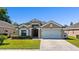 Charming single-story home featuring a well-manicured lawn and an attached two-car garage at 15501 Markham Dr, Clermont, FL 34714