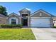 Charming single-story home featuring a well-manicured lawn and an attached two-car garage at 15501 Markham Dr, Clermont, FL 34714