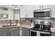Well-appointed kitchen with stainless steel appliances, granite countertops, and a view of the open-concept living area at 15501 Markham Dr, Clermont, FL 34714
