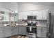 Modern kitchen featuring granite countertops, stainless-steel appliances, and a view to the living area at 15501 Markham Dr, Clermont, FL 34714