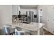 Bright kitchen with granite countertops, breakfast bar, and stainless-steel appliances adjacent to the laundry room at 15501 Markham Dr, Clermont, FL 34714