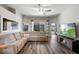 Bright living room featuring a sectional sofa, large windows, and hardwood flooring at 15501 Markham Dr, Clermont, FL 34714