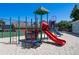 Vibrant playground with slides, climbers, and soft sand base, set against a backdrop of greenery and a community building at 15501 Markham Dr, Clermont, FL 34714