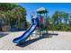 Brightly colored playground with slide, climbing structure, and soft sand surface for active fun, sunny day at 15501 Markham Dr, Clermont, FL 34714