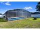 A screened-in pool surrounded by green grass and a white fence for privacy and outdoor enjoyment at 15501 Markham Dr, Clermont, FL 34714