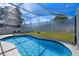Backyard pool with a screened enclosure, surrounded by lush greenery, offering a relaxing retreat at 15501 Markham Dr, Clermont, FL 34714