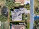 Aerial view of the home showcasing its roof, backyard with screened lanai, and driveway at 1573 Blenheim Trl, The Villages, FL 32162