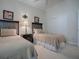 Neutral-toned bedroom featuring twin beds, carpeted floor, closet, and decorative artwork at 1573 Blenheim Trl, The Villages, FL 32162