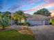 Charming single-story home with a three-car garage, beautiful landscaping, and a paved driveway at 1573 Blenheim Trl, The Villages, FL 32162