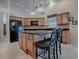 Bright kitchen with black appliances, granite countertops, central island with seating, and wooden cabinetry at 1573 Blenheim Trl, The Villages, FL 32162