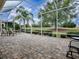 Screened lanai featuring stone flooring, outdoor seating, and a backyard golf course view at 1573 Blenheim Trl, The Villages, FL 32162