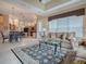 Living room featuring a large window for natural light, an area rug and access to the kitchen at 1573 Blenheim Trl, The Villages, FL 32162