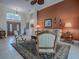 Spacious living room with double front doors, tan couches, and a ceiling fan at 1573 Blenheim Trl, The Villages, FL 32162