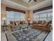 Open living room with large patterned area rug, two sofas and glass top coffee table at 1573 Blenheim Trl, The Villages, FL 32162
