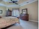 This spacious main bedroom offers beautiful furniture and serene natural lighting at 1573 Blenheim Trl, The Villages, FL 32162