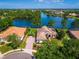 Stunning aerial view of the lakefront property showcasing lush landscaping, a brick driveway and water views at 2029 Stefano Ct, Mount Dora, FL 32757