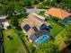 Aerial view of home showcasing pool, solar panels, and manicured yard at 2029 Stefano Ct, Mount Dora, FL 32757