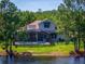 Beautiful backyard pool with screened enclosure and waterfront view, surrounded by lush greenery and mature trees at 2029 Stefano Ct, Mount Dora, FL 32757