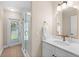 Bright bathroom features a walk-in shower and door leading to backyard, great for pool access at 2029 Stefano Ct, Mount Dora, FL 32757