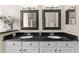 Bathroom featuring double sinks, granite countertop, and framed mirrors with a view to the standing shower provides a great space at 2029 Stefano Ct, Mount Dora, FL 32757