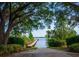 Scenic view of a private wooden boat dock on a tranquil lake, surrounded by lush vegetation and a concrete boat launch at 2029 Stefano Ct, Mount Dora, FL 32757