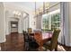 Bright dining room featuring a wooden table, elegant lighting, and a large window with views of the outdoors at 2029 Stefano Ct, Mount Dora, FL 32757