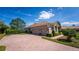 Charming home featuring a paved driveway, three-car garage, manicured bushes, and landscaped front yard at 2029 Stefano Ct, Mount Dora, FL 32757