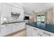 Bright kitchen featuring white cabinets, blue countertops, an island, and stainless steel appliances at 2029 Stefano Ct, Mount Dora, FL 32757