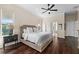 This main bedroom with hard wood floors and a ceiling fan includes access to the ensuite bathroom and walk in closet at 2029 Stefano Ct, Mount Dora, FL 32757
