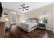 Spacious main bedroom with dark hardwood floors, large windows, and ceiling fan ensures a comfortable and stylish retreat at 2029 Stefano Ct, Mount Dora, FL 32757