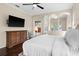 Bright main bedroom offers a tranquil space with a view of the outdoors with dark wood floors and ceiling fan at 2029 Stefano Ct, Mount Dora, FL 32757