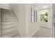 Carpeted stairway featuring a handrail and a gallery wall with natural light from the window at 2029 Stefano Ct, Mount Dora, FL 32757