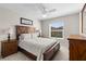 Cozy bedroom with a wooden bed frame, two nightstands, and a large window at 2170 Biller Cir, The Villages, FL 32163