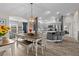 Open-concept dining room flowing into kitchen with hardwood floors and stylish lighting at 2170 Biller Cir, The Villages, FL 32163