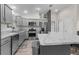 A spacious kitchen features stainless appliances, gray cabinets, granite countertops and a functional kitchen island at 2170 Biller Cir, The Villages, FL 32163