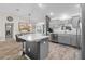 Open kitchen features an island with bar seating, stainless steel appliances and hardwood style flooring at 2170 Biller Cir, The Villages, FL 32163