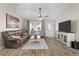 Cozy living room with hardwood floors, neutral paint, ceiling fan, and a large window for natural light at 2170 Biller Cir, The Villages, FL 32163