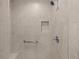 Beige tiled shower featuring a shower head, grab bar, niche, and a seating area at 2170 Biller Cir, The Villages, FL 32163
